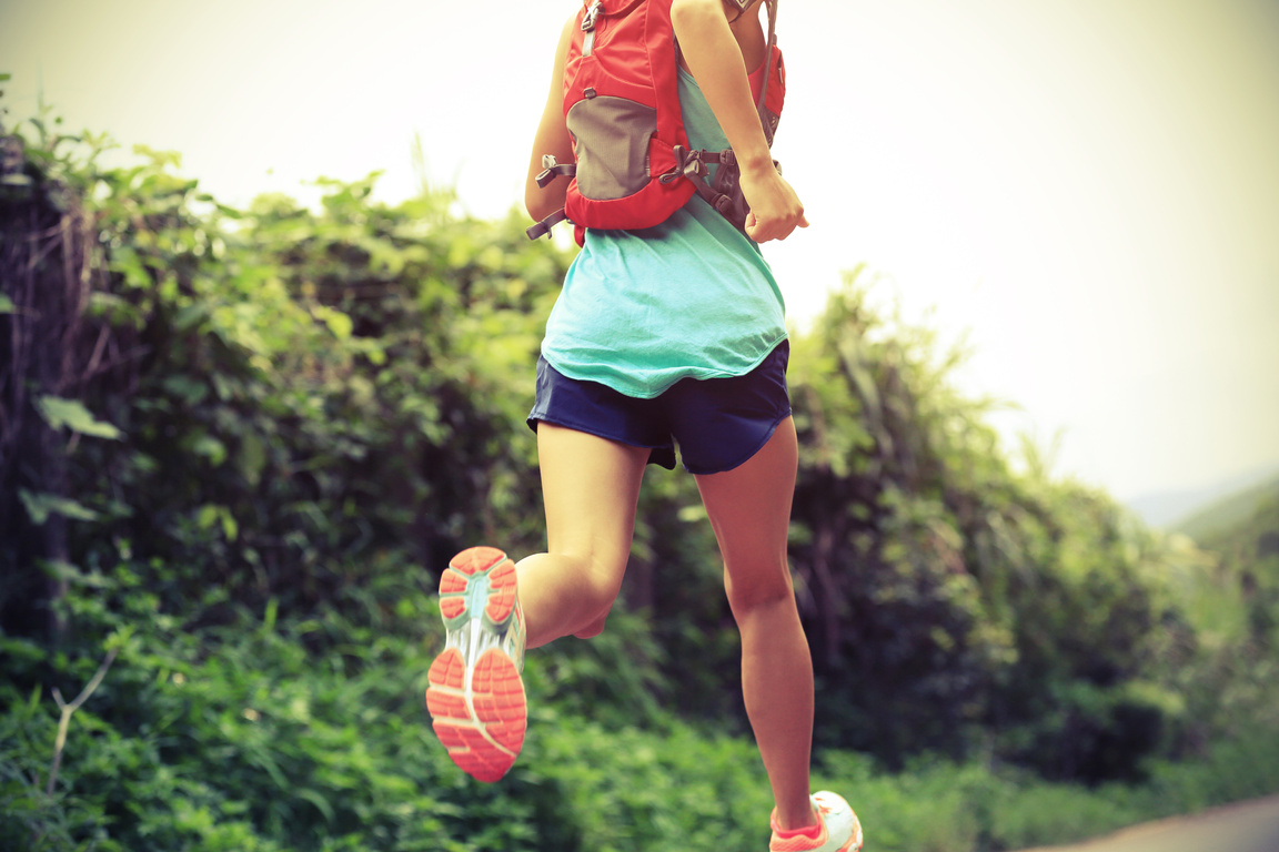 trail runner athlete running on forest trail.